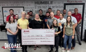 Dec-O-Art presenting a large check to Care Camps Foundation with team surrounding
