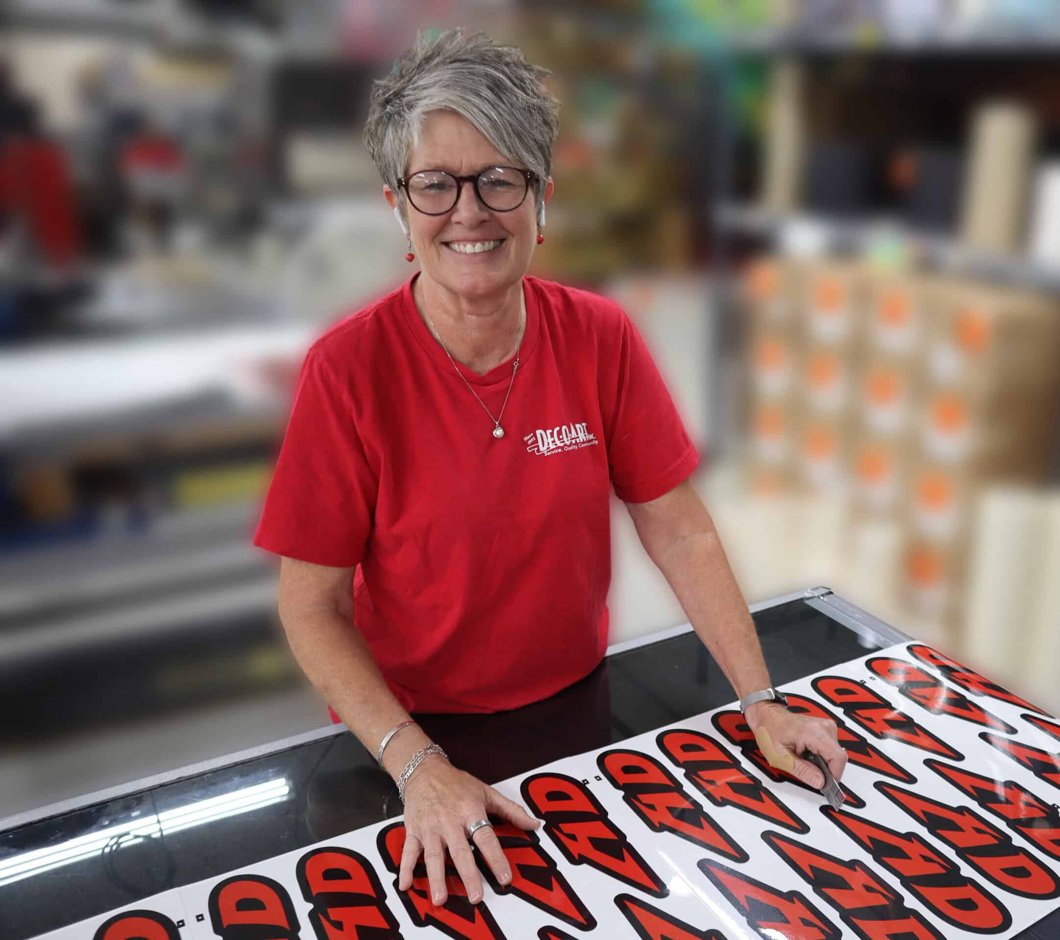 Smiling woman in factory setting with labels in front of her